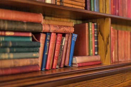 a pile of books sitting on a shelf at Nordfjord Hotell in Nordfjordeid