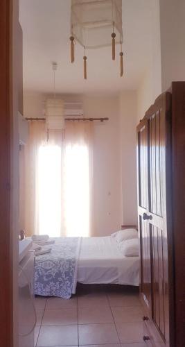 a bedroom with a bed and a window at Arianna in Paleokastritsa