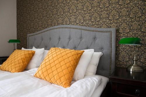 a bedroom with a bed with yellow pillows at Hotell Blå Blom in Gustavsberg