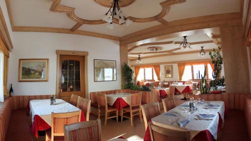a restaurant with tables and chairs in a room at Albergo Passo Brocon in Castello Tesino