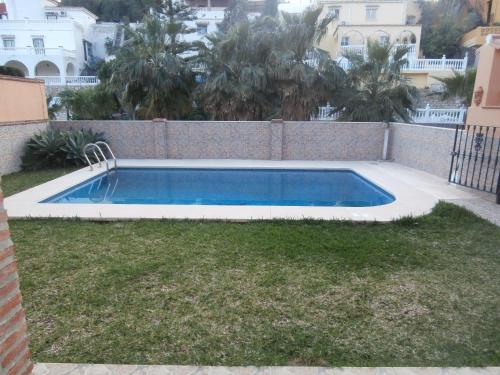 - une piscine dans une cour à côté d'une clôture dans l'établissement La Casa del Jazmín, à Benalmádena