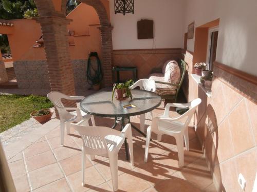 a patio with a table and chairs and a couch at La Casa del Jazmín in Benalmádena