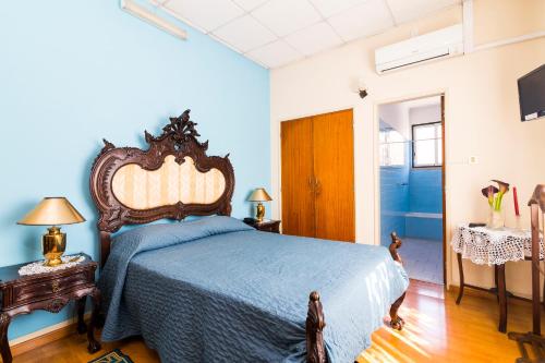 um quarto com uma cama com uma colcha azul em Hotel Santa Rita em Monte Real