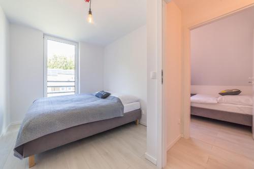 1 dormitorio con 2 camas y ventana en Apartamenty PAX, en Dziwnów