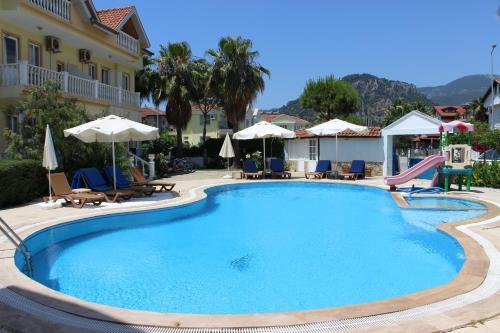 a large swimming pool with chairs and a slide at Mavikosk in Dalyan