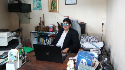 a woman sitting at a desk with a laptop at Monalysa St Honore Apartment & Studios Grand Bay in Grand Baie