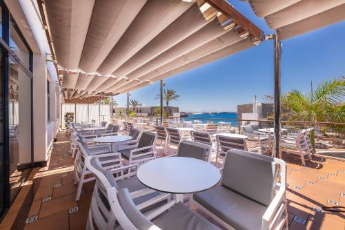 a patio with tables and chairs and the ocean at Hotel Mirador Papagayo by LIVVO in Playa Blanca