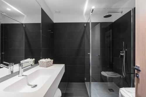 a bathroom with a shower and a sink and a toilet at Hotel Lago Di Garda in Nago-Torbole