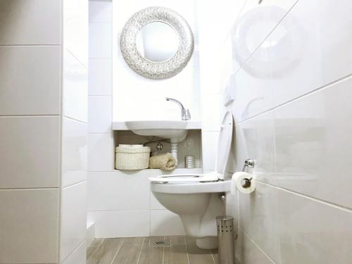 a white bathroom with a toilet and a mirror at Perello Old Town in Split