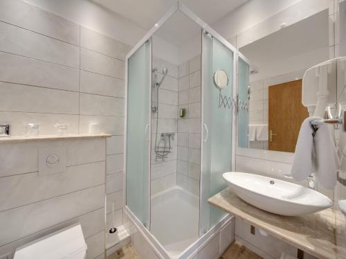 a white bathroom with a shower and a sink at Hotel Villa Adriatica - Adults Only in Supetar