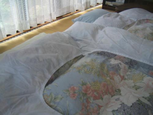 a bed with a blanket on top of it at Japanese Style Inn Dohzen Miwa in Niimi