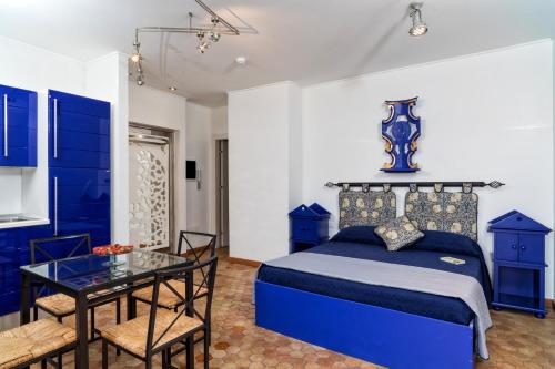 Dormitorio azul con cama y mesa de cristal en Medea Residence appartamenti vacanze en Taormina