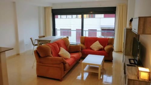 a living room with a couch and a table at Apartamentos Prado in Peniscola