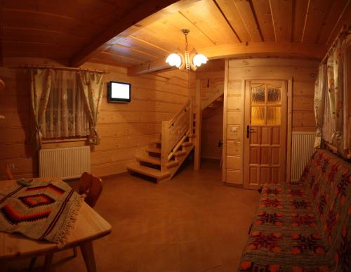 a room with a couch and stairs in a cabin at Pensjonat Willa Szarotka in Kluszkowce