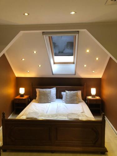 ein Schlafzimmer mit einem Bett mit einem Fenster und zwei Lampen in der Unterkunft Mosoly Apartman in Szeged