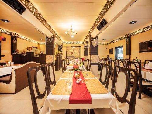 a dining room with tables and chairs in a restaurant at FabHotel Santoor Geeta Bhawan Square in Indore