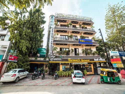 a tall building with cars parked in front of it at FabHotel Santoor Geeta Bhawan Square in Indore