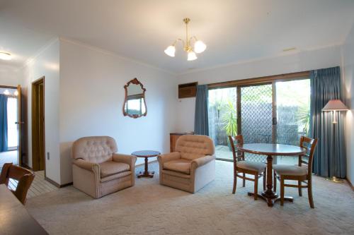 a living room with a table and chairs at Golden Grain Motor Inn in Horsham