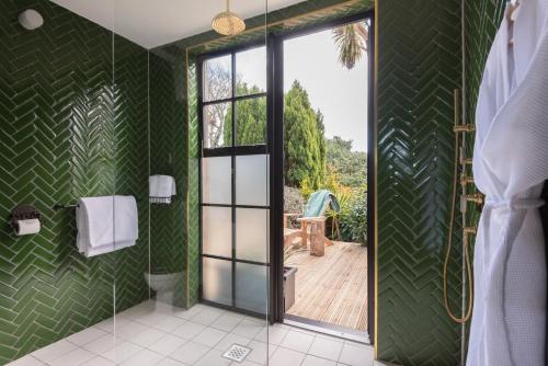 ファルマスにあるMerchants Manor Spaの緑の壁とガラスのスライドドアが付いたバスルーム