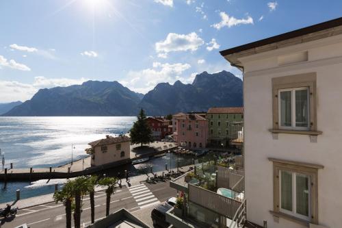 a view of a city and the water with mountains at Hotel Lago Di Garda in Nago-Torbole