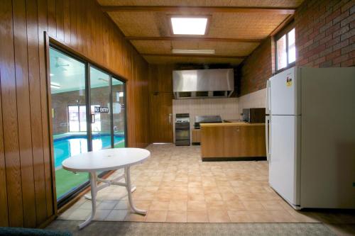 a kitchen with a white table and a refrigerator at Golden Grain Motor Inn in Horsham