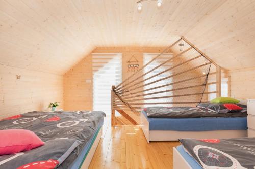 two beds in a room with a staircase at Sun-Holiday Domki letniskowe in Rewal