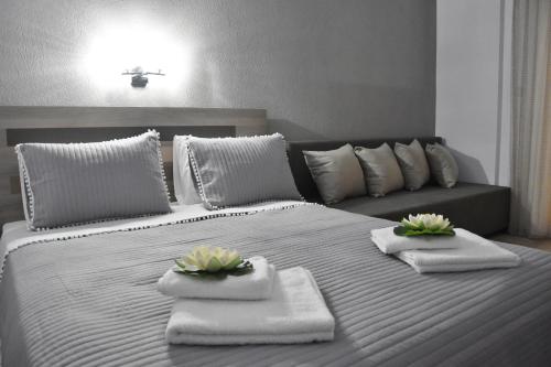 ein großes weißes Bett mit Handtüchern und Blumen darauf in der Unterkunft Dream Studios in Stavros