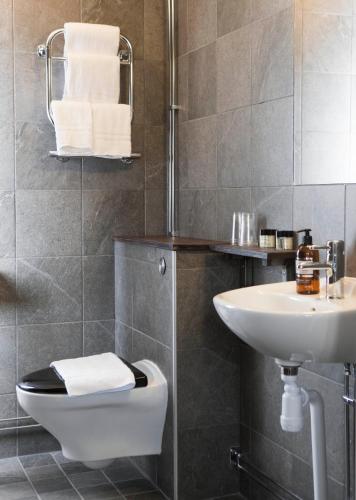 a bathroom with a toilet and a sink at Hotell Blå Blom in Gustavsberg