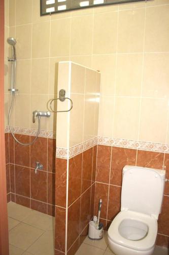 a bathroom with a shower and a toilet in it at Rainville Apartments in Paramaribo