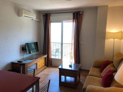 a living room with a couch and a tv at Mirador Castillo La Iruela in Cazorla