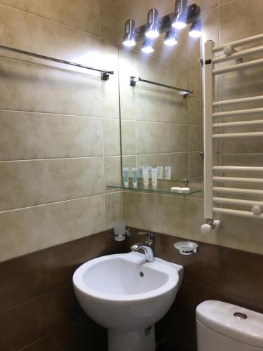 a bathroom with a white sink and a toilet at Sweet Rooms Inn in Tbilisi City