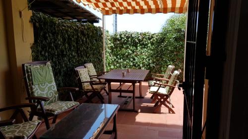 patio ze stołem, krzesłami i parasolem w obiekcie Jardines Del Golf w mieście Chilches