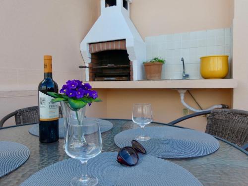 een tafel met twee glazen en een fles wijn bij Kasa Sunshine in Olhão