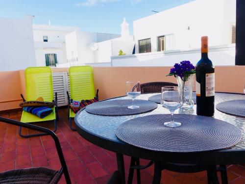 a table with two glasses and a bottle of wine at Kasa Sunshine in Olhão