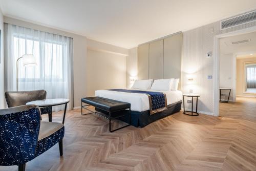 um quarto de hotel com uma cama e uma cadeira em Eurostars Gran Hotel Lugo em Lugo