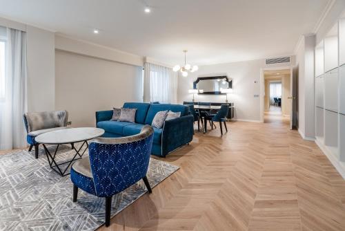 a living room with a blue couch and a table at Eurostars Gran Hotel Lugo in Lugo