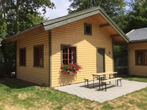 una pequeña casa con una mesa de picnic y un banco en Hollands Oostenrijks huisje en Wieringerwerf