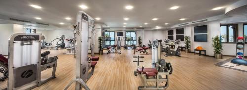 a gym with treadmills and elliptical machines at Bahi Ajman Palace Hotel in Ajman 