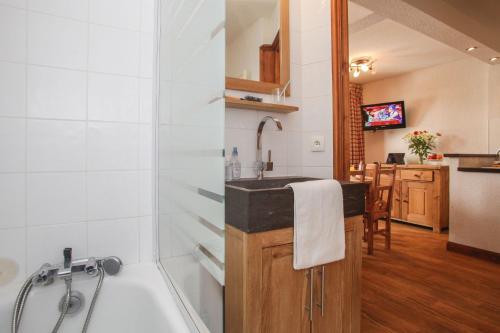 ein Badezimmer mit einem Waschbecken und einer Badewanne in der Unterkunft Résidence Odalys Val-Claret in Tignes