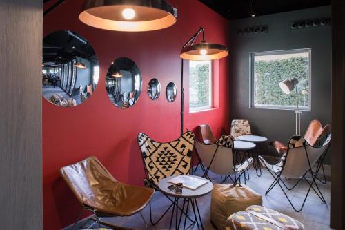 a red room with chairs and tables and mirrors at Ibis Madrid Fuenlabrada in Fuenlabrada
