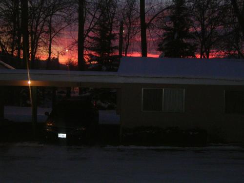 a car parked in front of a house at night at Johnny's Motel in Grand Forks