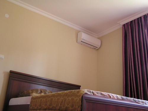 a bedroom with a bed with a air conditioner on the wall at Private Cottage at the Black sea in Shekvetili