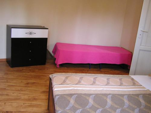 a room with a pink bed and a dresser at Private Cottage at the Black sea in Shekvetili