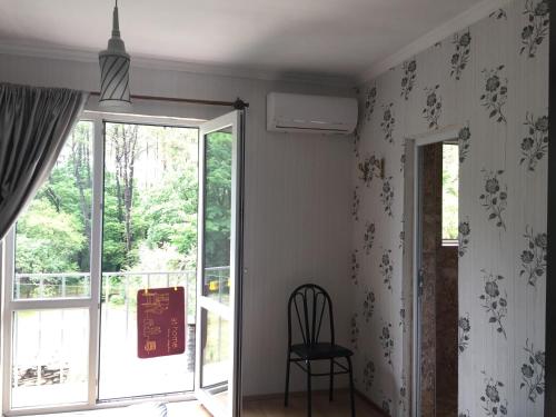 a dining room with a chair and a window at Private Cottage at the Black sea in Shekvetili