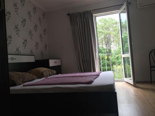 a bedroom with a bed and a large window at Private Cottage at the Black sea in Shekvetili