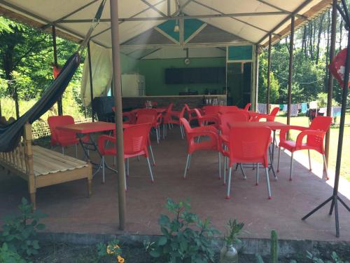 a group of red chairs and tables under a tent at Private Cottage at the Black sea in Shekvetili
