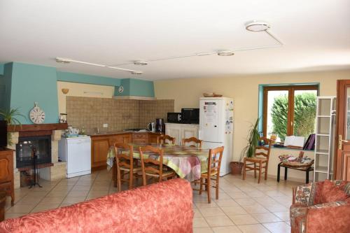 a kitchen and living room with a table and chairs at La Bardelière in Corbelin