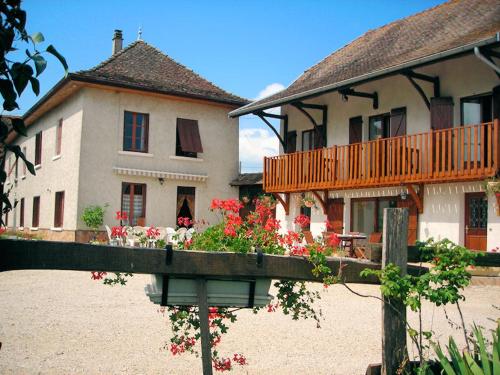 a house with a balcony and flowers in front of it at La Bardelière in Corbelin