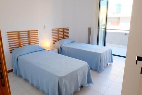 due letti in una stanza con finestra di Azzurra Casa Vacanze a Vasto