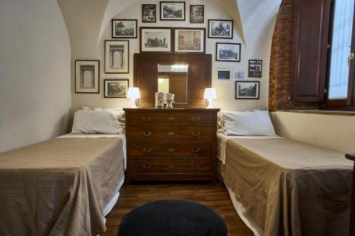 two beds in a room with pictures on the wall at Centro Storico in Chiari